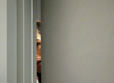 Cristiano Ronaldo takes a glimpse through a gap in the door during a press conference before the Portugal-Sweden game.