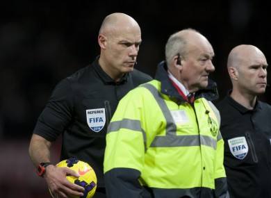 Referee Howard Webb, left, walks from the pitch after Manchester United's 2-1 loss to Tottenham