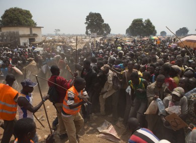 Security volunteers use sticks to fend off the crowd trying to enter a food and supplies distribution point, at a makeshift camp housing an estimated 100,000 displaced people, at Mpoko Airport, in Bangui, Central African Republic.