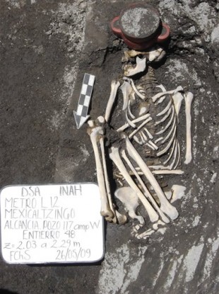 A 2009 image of the skeleton of a person lying next to an incense holder after it was found during Mexico City excavations.