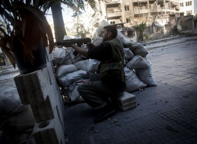 A rebel Free Syrian Army soldier shoots his machine gun towards Syrian Army positions in Aleppo