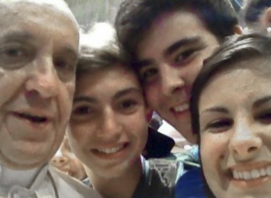 Pope Francis in a selfie from inside St Peter's Basilica with young people on pilgrimage at the Vatican.