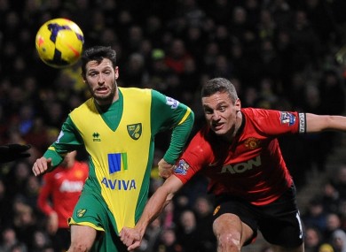 Wes Hoolahan chases the ball under the close supervision of Manchester United's Nemanja Vidic.