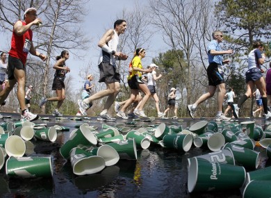 Runners make their way through discarded cups in Boston.