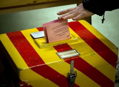 A voter puts his ballot into a box at a polling statio near Geneva today.