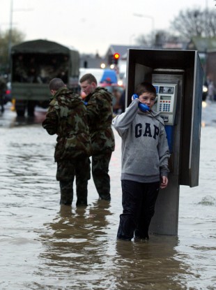 Kevin Kinsella from Ballybough speaks to a friend on a public telephone during flooding in Dublin in 2002.