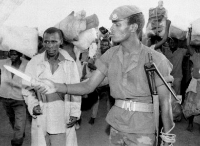A soldier points a knife at a group of refugees on the Burundi / Rwanda border 20 April 1994.