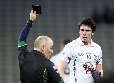 Marty Duffy shows Kildare's David Hyland a black card.