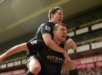 Samir Nasri helps Edin Dzeko celebrate his goal.