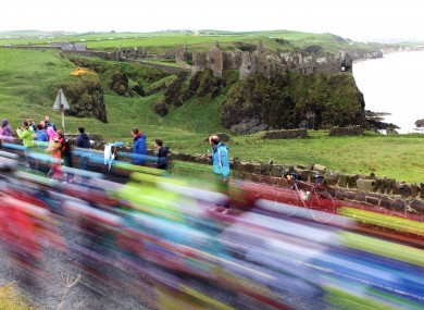 Riders pictured traveling past Dunluce Castle.