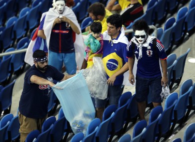 Fans clean up after themselves after one of the group matches.