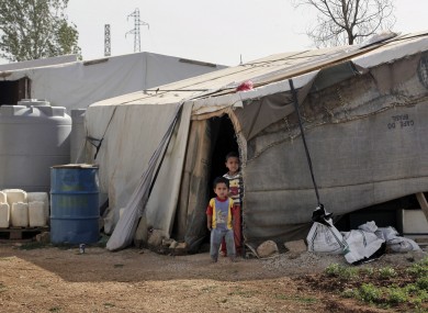 Syrian refugee children stand outside their tent at a Syrian refugee camp in the eastern Lebanese town of Majdal Anjar.