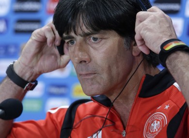 Joachim Löw adjusts a headset during a news conference.