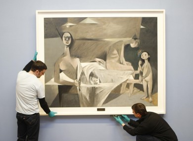 Art handlers from the National Gallery of Ireland in Dublin hang Louis Le Brocquy's 'A Family'.