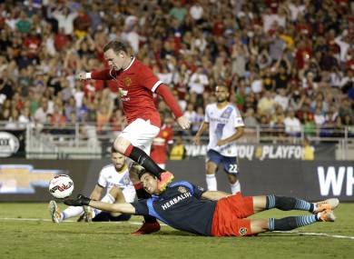 Manchester United's Wayne Rooney, top, scores past Los Angeles Galaxy goalkeeper Jaime Penedo.