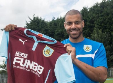 Reid holds up the Burnley jersey.