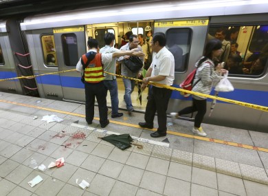 File photo dated 21/5/14 showing officials blocking parts of the knife attack scene at a subway platform in Taipei, Taiwan.