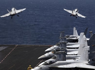 U.S. F/A-18 fighter jets take off for a mission in Iraq from the flight deck of an aircraft carrier in the Persian Gulf.