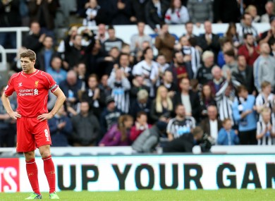 Liverpool's captain Steven Gerrard stands dejected as Newcastle United's Ayoze Perez celebrates earlier.