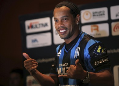 Brazil's Ronaldinho poses for a photo after slipping on his new Queretaro soccer club jersey at a press conference in Mexico City last September.