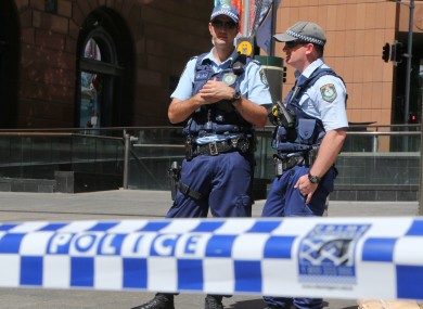 Police stand near a police line to stop pedestrian access close to a cafe under siege at Martin Place in Sydney in December.