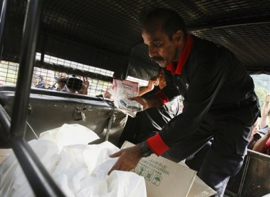 A Malaysian Forensic team personnel places bags of human remains found at the abandoned camps for transportation from the Malaysia-Thailand border in Wang Kelian.