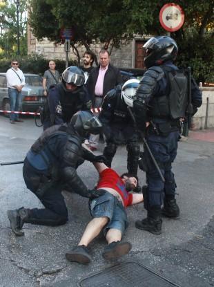 Riot police detains a demonstrator before a rally in Athens.