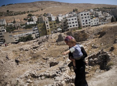 A Palestinian woman carries her baby in the city of Nablus near where the attack took place.