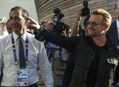 Bono waves as he arrives for a visit to Expo 2015 in Milan.