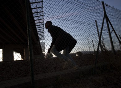 A migrant attempts to enter the Channel Tunnel at Calais in August