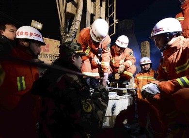 Rescuers try to contact the trapped people at a collapsed mine in Pingyi County, east China's Shandong Province
