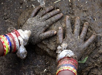 A woman makes cow dung cakes in Allahabad, India.