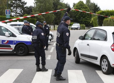 French police officers work at the crime scene the day after a knife-wielding attacker stabbed a senior police officer to death.