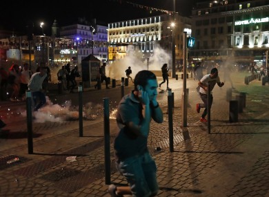 People run after police fire tear gas following clashes after the Euro 2016 soccer championship group B match between England and Russia in Marseille.