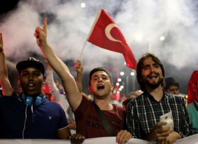Pro-government supporters chant slogans and wave flags as they protest on Istanbul's iconic Bosporus Bridge on Thursday.