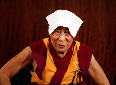 Tibetan spiritual leader the Dalai Lama wears a towel on his head to cool off during a press conference in Paris today.