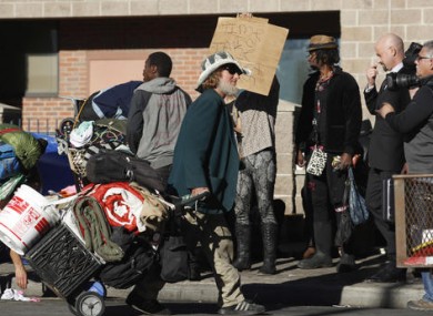 Homeless man dragging his belongings following police action in Denver