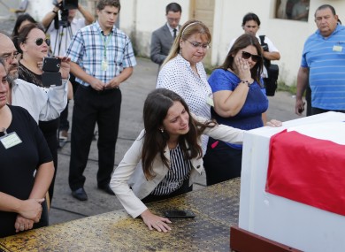 Relatives of Paraguayan Gustavo Encina who died in Monday's plane crash attend the arrival of the coffin, which is covered with a Paraguayan flag, at Silvio Pettirossi airport, Paraguay.