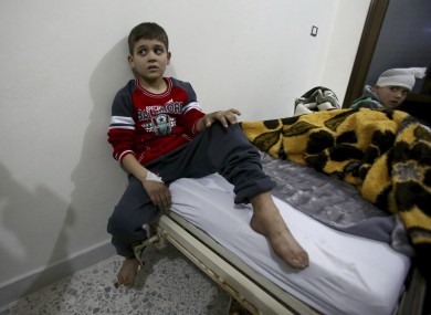 Syrian boys, evacuated from Aleppo, sit in a field hospital bed near Idlib, Syria.