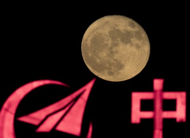 The logo for AVIC, or Aviation Industry Corp, silhouetted on front of a supermoon.