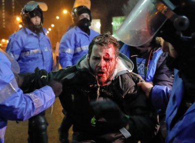 Romanian riot police detain a man after minor clashes erupted during a protest in Bucharest yesterday