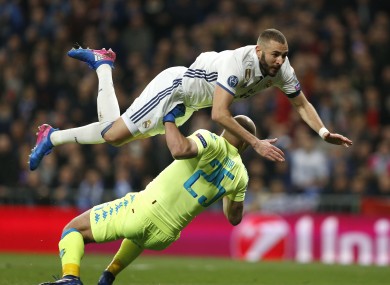 Real Madrid's Karim Benzema jumps over Napoli goalkeeper Pepe Reina.