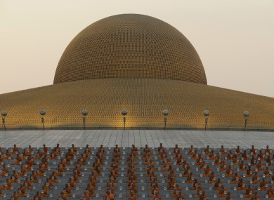 Thai Buddhist monks pray and gather at Wat Dhammakaya temple.