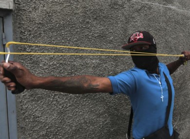 A youth aims his sling during anti-government protests in Caracas yesterday