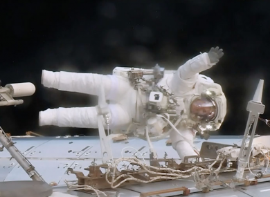 Astronaut Jack Fischer waves while attached to the Destiny laboratory during a spacewalk to replace a failed data relay box and install a pair wireless antennas.