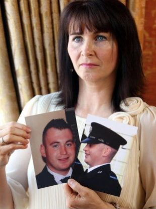 Nuala, mother of murdered Constable Ronan Kerr, holds photos of Ronan.
