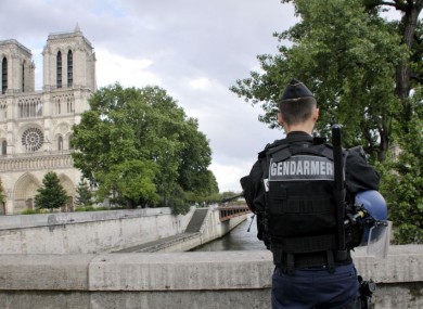 A police officer stands near the entrance of Notre Dame cathedral in Paris on Tuesday