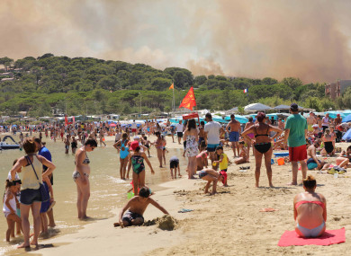 Beach goers watch as fires rage in Bormes-les-Mimosas, south-east France