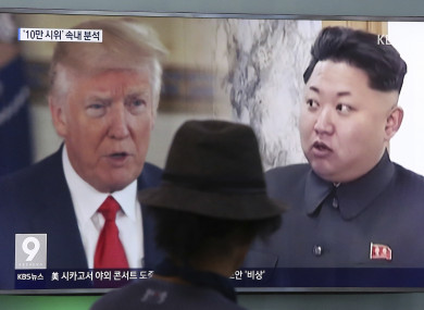 A man watches a TV screen showing a local news program reporting about North Korea's missiles.
