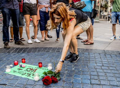 People lay flowers and candlelights in Las Ramblas avenue a day after the deadly van attack in Barcelona.